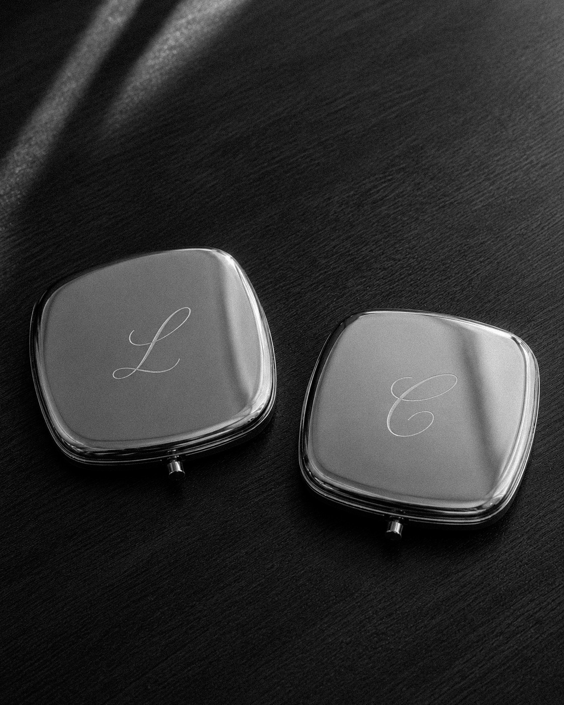 Dos espejos de bolso con la inicial grabada, acabado plateado
