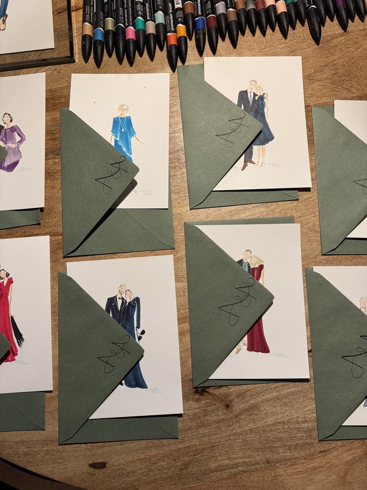 Ilustraciones de invitados con sobres verdes e iniciales A&A sobre una mesa de madera