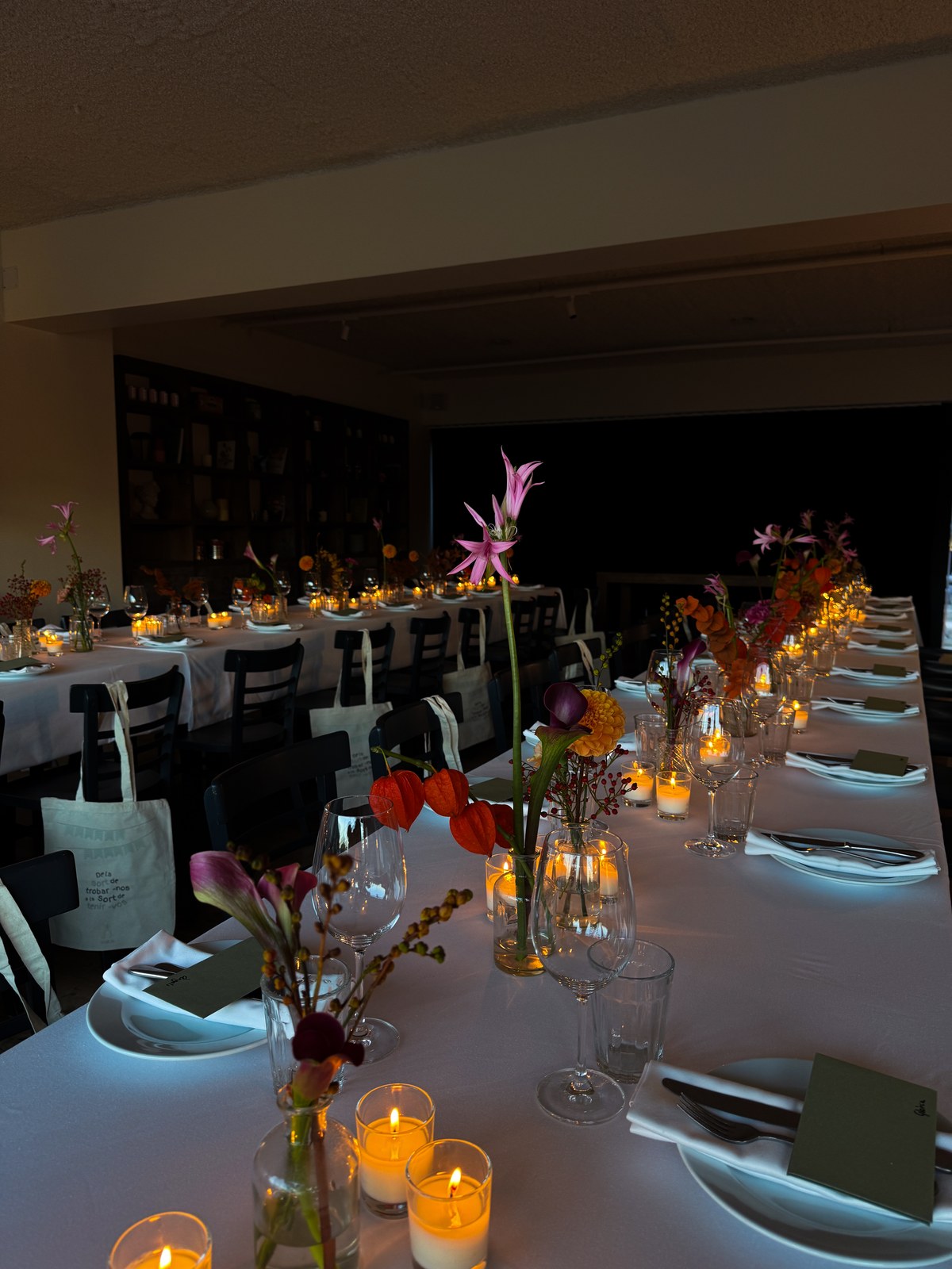 Mesas preparadas en Osteria Nonna con velas, flores y detalles verdes