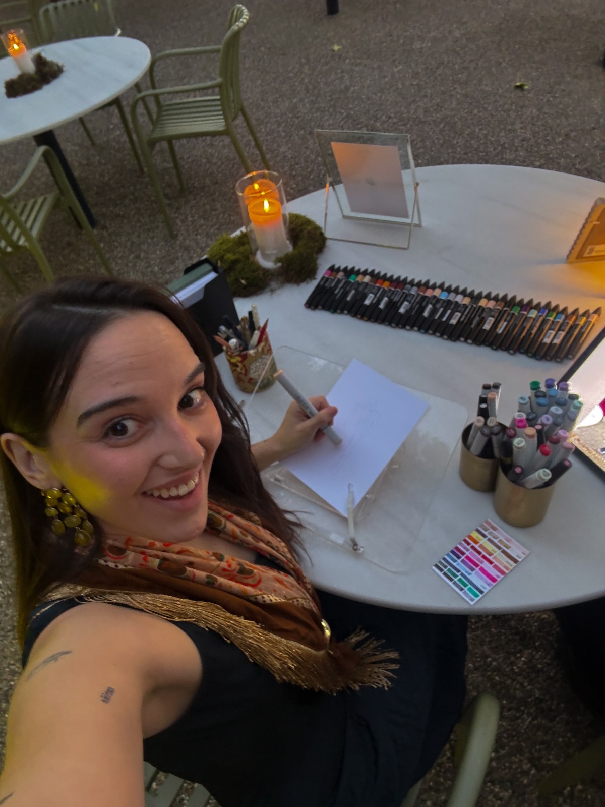 Lorena junto a la mesa de ilustración en directo preparada al aire libre